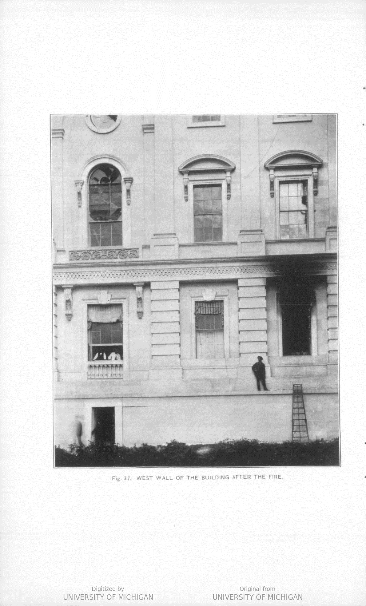 Exterior view of the west wall of the Capitol. Windows on the top floor have shattered glass, and one on the main floor is completely blown out and stained black from smoke.