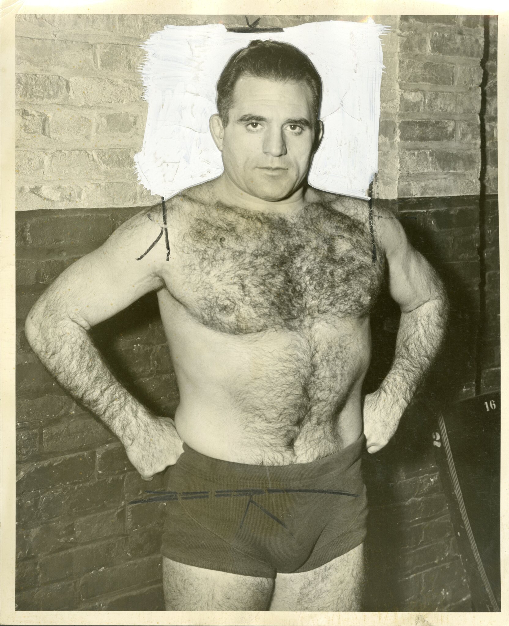 Michele Leone with his hands at his sides in wrestling trunks