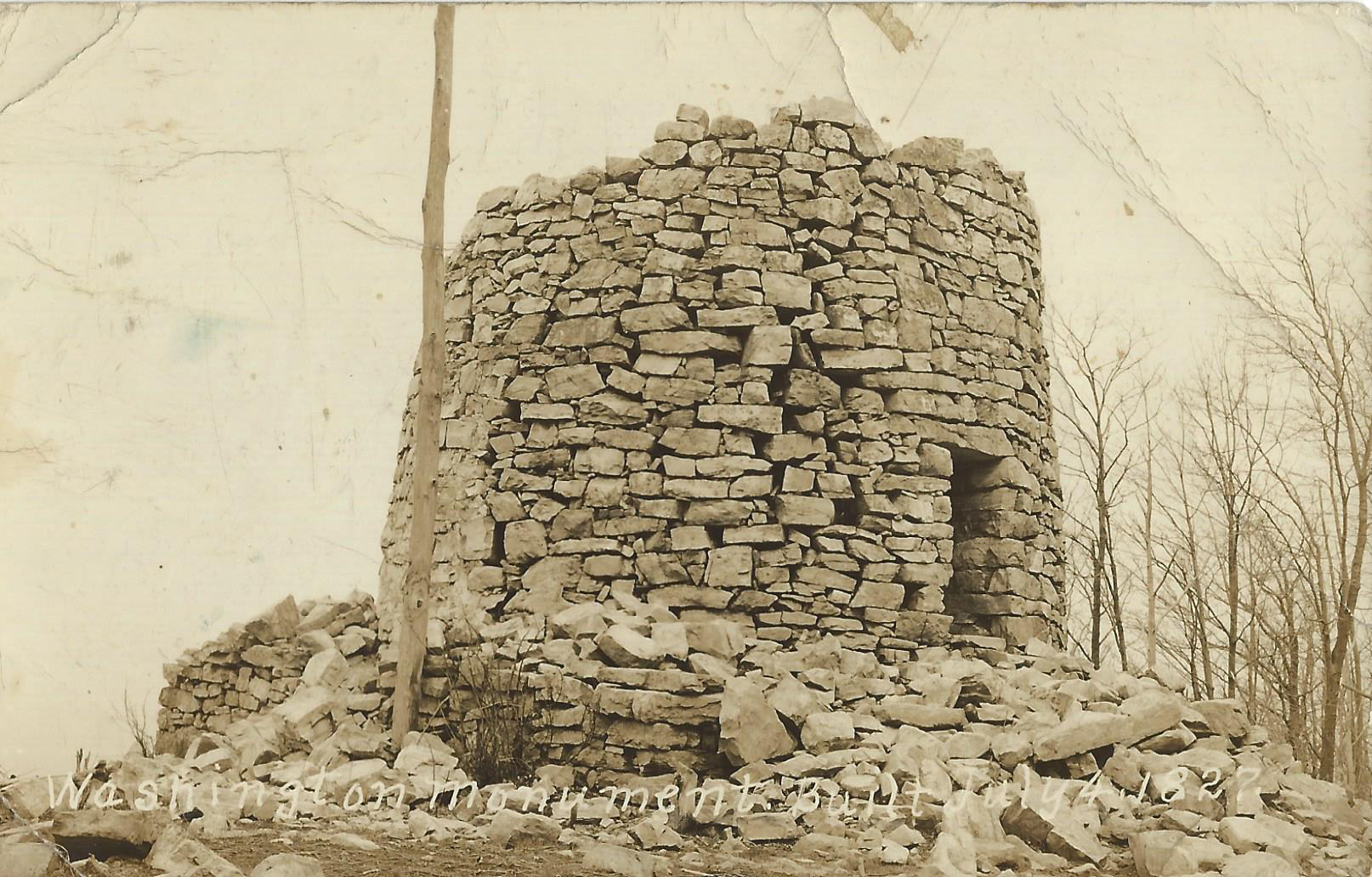 A tan toned image of a stone tower with rubble around it