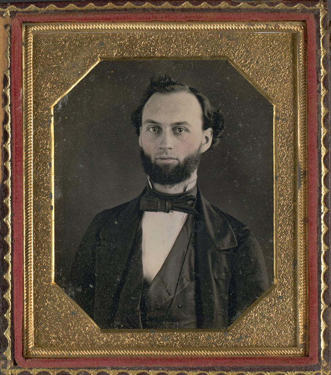 19th century black and white portrait of man with beard in gold frame. 