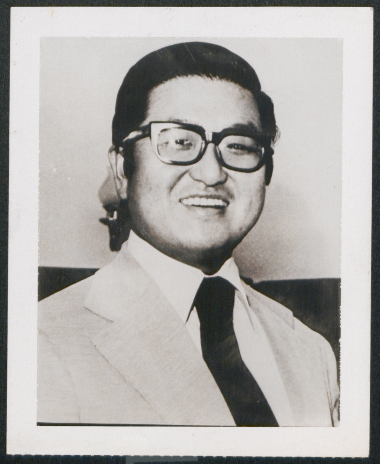 Tongsun Park smiles, wearing a suit
