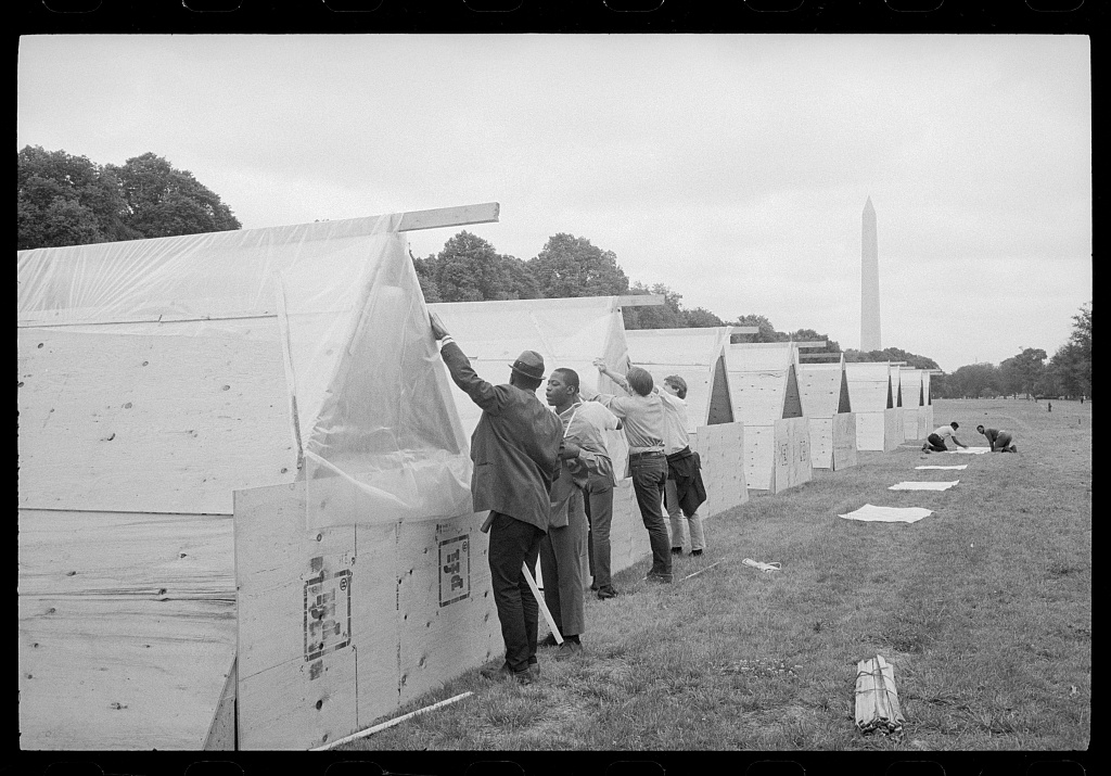 A row of tents with Washington Monument in the background.