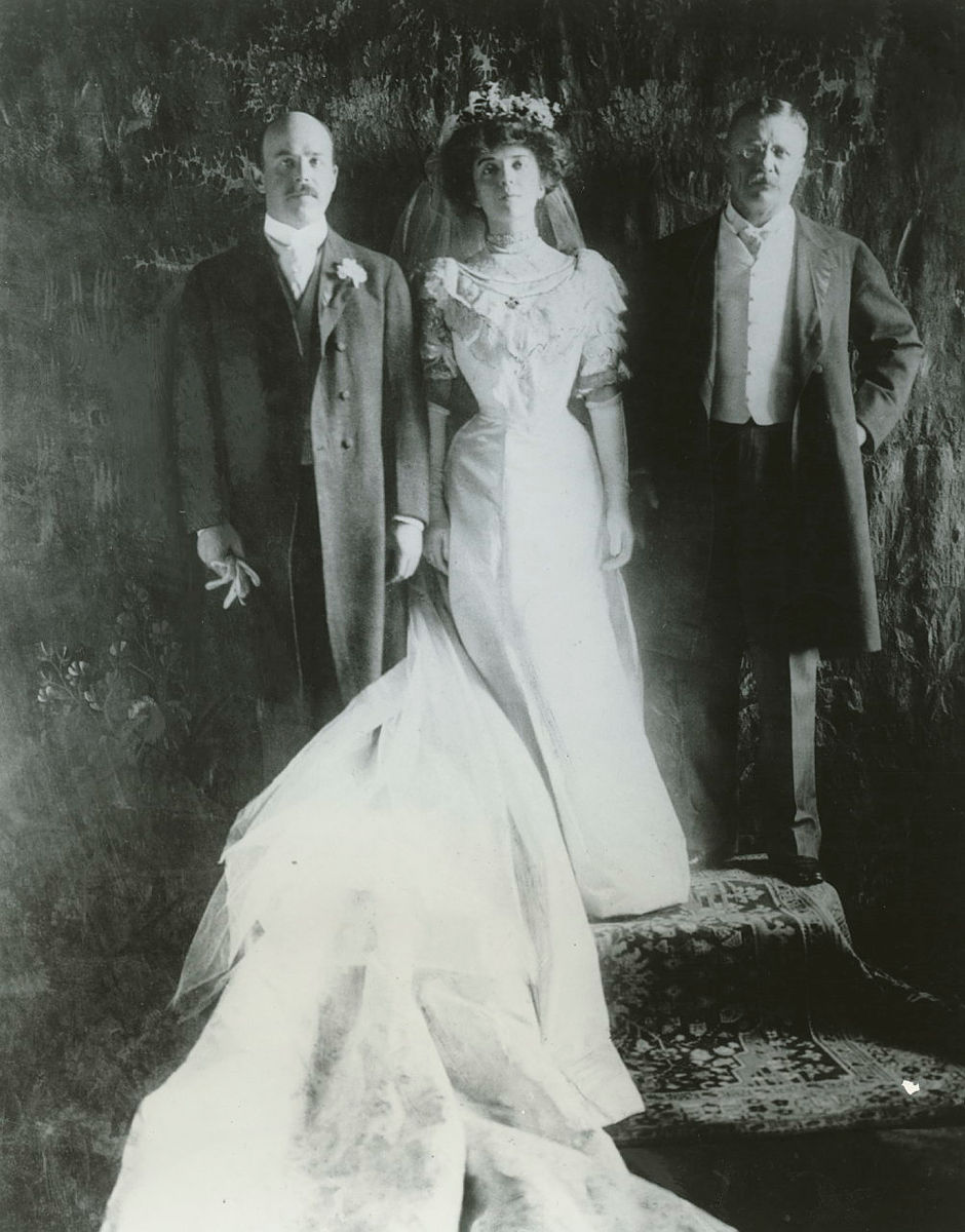 Back and white portrait of Alice Roosevelt in wedding dress flanked by Nicholas Longworth and President Teddy Roosevelt.