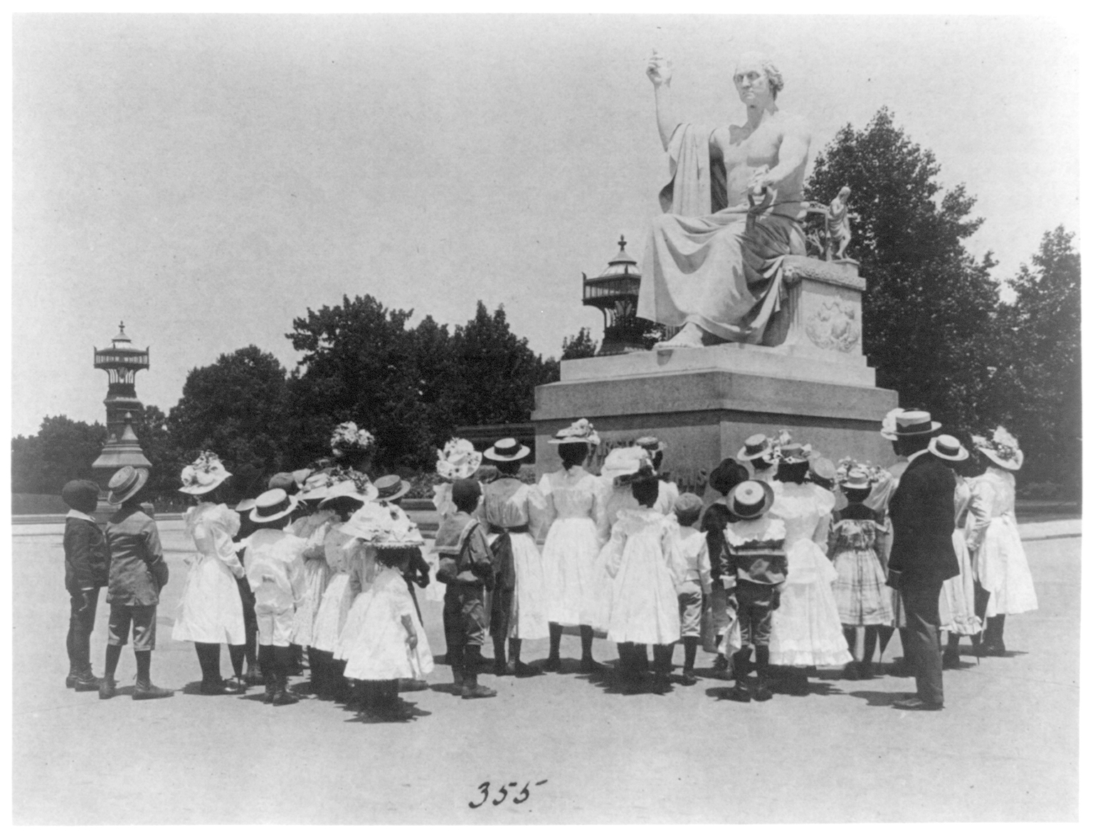 Group of African American school children look at Horatio Greenough statue of George Washington c. 1899