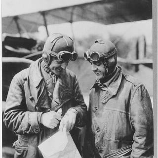 Major Reuben Fleet and Lieutenant George Boyle standing in front of the Jenny plane with a map.