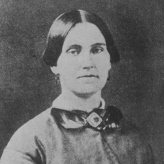 Portrait of Mary Surratt, a middle-aged woman in a dark dress, looking into the camera. Source: Wikimedia Commons