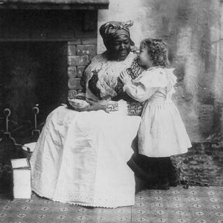 Picture of a seated black "mammy" listening to a small white girl. Source: Library of Congress