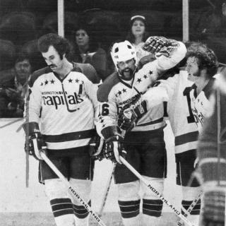 Three Washington Capitals players stand together on ice during 1974 season.