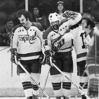 Three Washington Capitals players stand together on ice during 1974 season.