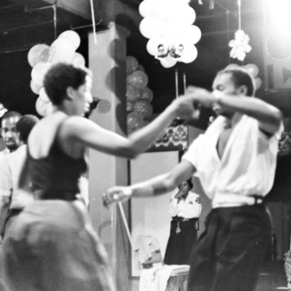 Two people dancing during a night at the ClubHouse, surrounded by party decorations and other attendees.