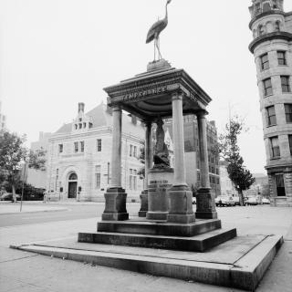Black and white photo of statue with four pillars and a roof inscribed with "Temperance" on it.