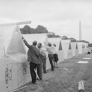A row of tents with Washington Monument in the background.