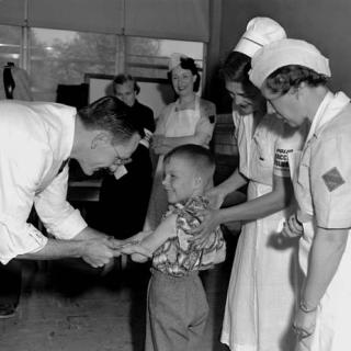 Dr. Richard Mulvaney administers the trial Polio vaccine to Randall Kerr with two nurses looking on