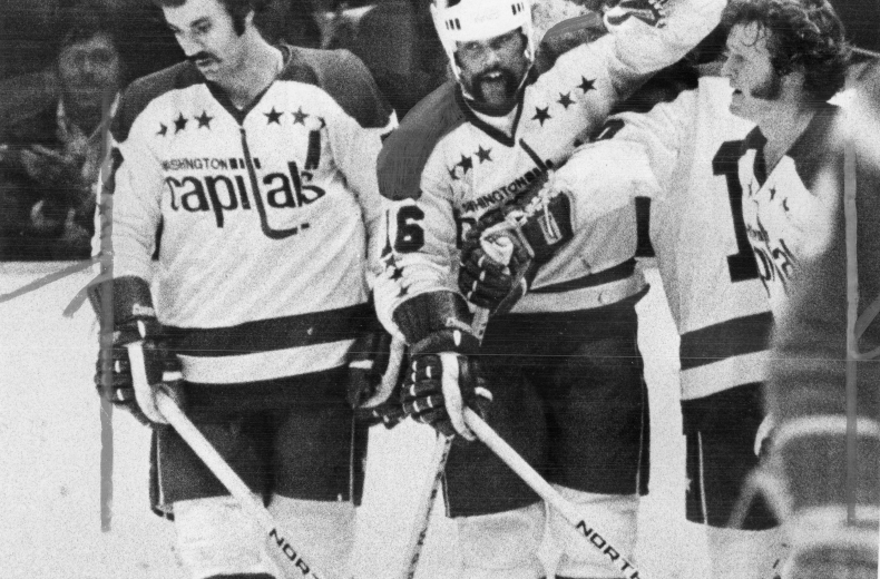 Three Washington Capitals players stand together on ice during 1974 season.