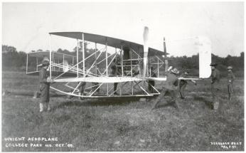 Starting up the Military Flyer engine with Wilbur Wright (fourth from left, behind engine) looking on at College Park, October 1909. Personnel are from the Army Signal Corp. Photo courtesy of the College Park Aviation Museum.