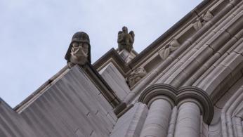 A view from below of the Darth Vader grotesque on the side of the Cathedral with another sculpture out of focus behind it