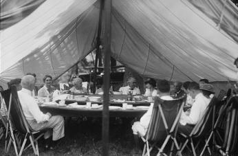 Thomas Edison, Warren Harding, Henry Ford, and others seated around their large collapsible dining table