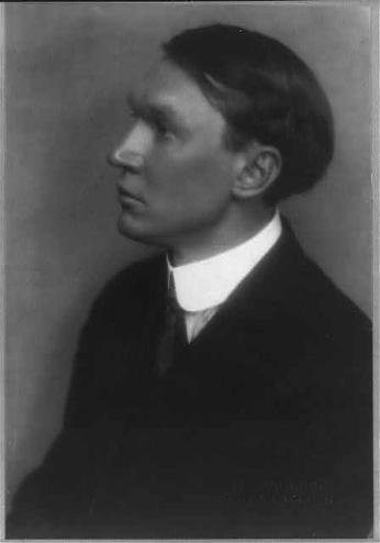 A black-and-white photo of Nicholas Vachel Lindsay standing in profile, wearing a suit