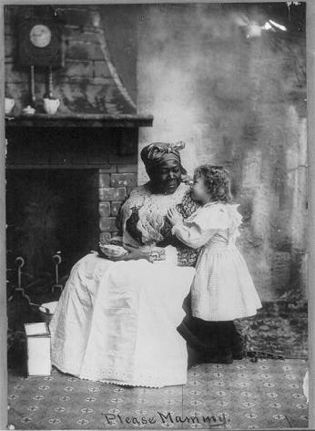 Picture of a seated black "mammy" listening to a small white girl. Source: Library of Congress