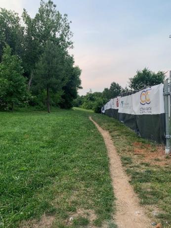 A desire path through the grass at Fort Reno. To the right is a construction site, and to the left are trees. (Source: Mary-Kate Wilson)