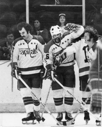 Three Washington Capitals players stand together on ice during 1974 season.