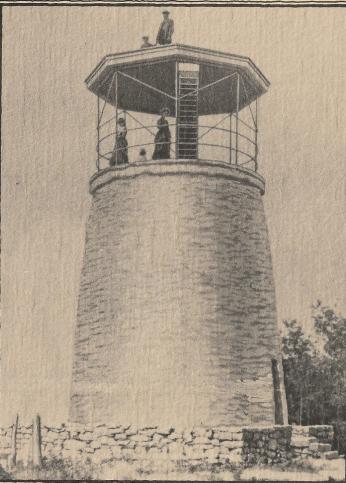 A stone tower with people on top