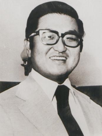 Tongsun Park smiles, wearing a suit