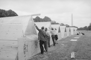 A row of tents with Washington Monument in the background.