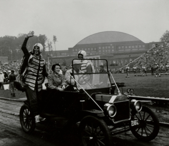 Students dressed as terrapin mascots ride in car around track, Byrd Stadium, University of Maryland, circa September 1955