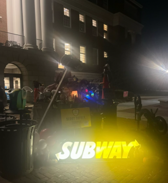 A photo of piled-up testudo offerings, including a lit Subway store sign