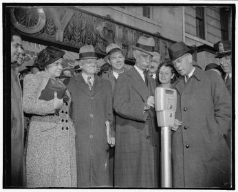 Commissioner Melvin Hazen and William Van Duzer, putting the first nickel in the parking meters ordered by Congress for a test in Washington in November 1938. 