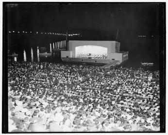 Hans Kindler conducts the NSO on the concert barge at the Watergate Amphitheatre in 1939.  (Photo Source: Library of Congress) https://www.loc.gov/pictures/item/hec2009013682/