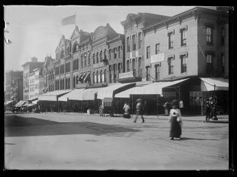 “View of various stores and shops on 7th Street, N.W., West side, looking South from E Street” (Photo Source: Library of Congress) View of various stores and shops on 7th Street, N.W., West side, looking South from E Street. Washington D.C, 1901. Photograph. https://www.loc.gov/item/2016646096/.