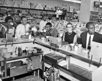 Non-violent Action Group members enjoy a cup of coffee at an Arlington Drug Fair lunch counter on June 23, 1960, one day after the counter was integrated. (Source: Washington Area Spark on Flickr.)