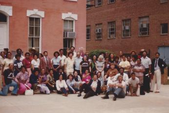 Photograph from the first Black Deaf Advocates conference in 1981 A photograph of a large group of people sitting and standing outside of a brick building
