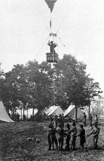 Balloon ascending into the air on a Civil War battlefield.
