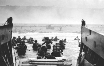 U.S. Soldiers disembark a landing craft at Normandy, France, June 6, 1944. By the end of the day some 150,000 Allied troops had landed on five Normandy beaches and three airborne drop zones. The invasion marked the beginning of the final phase of World War II in Europe, which ended with the surrender of Germany the following May. (Source: Wikimedia Commons, U.S. Department of Defense photo courtesy of the National Infantry Museum/Released) 