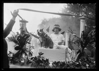 A black and white photograph of Stubby and Louise Johnson. They sit in a decorative float. Stubby wears his uniform and Louise Johnson wears fashionable 1920s clothing. 