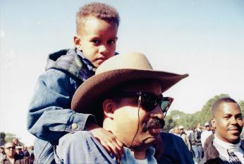 Father with son on his shoulders at the Million Man March, 1995
