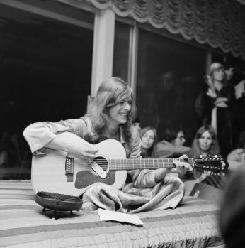 A pre-glam David Bowie jams plays the guitar at a party