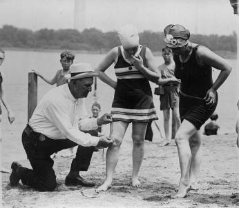 Officer Bill Norton measures a woman's suit to make sure it meets the six-inch requirement in 1922.