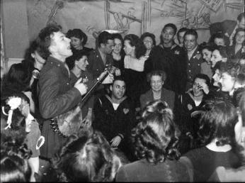 Pete Seeger performing at a party at the Congress of Industrial Organizations canteen in Washington DC in 1944, as First Lady Eleanor Roosevelt looks on. Credit: Library of Congress.