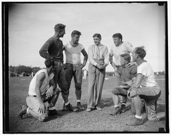 George Marshall, owner of the Washington Redskins, talks it over with some of his players, left to right: Wayne Millner, tackle, end, Charlie Malone, end,. Vic Carroll, Tackle,. George Marshall, Bill Young, Tackle, Ed Michaels, Guard, Jim Garber, Tackle,. 9/11/37