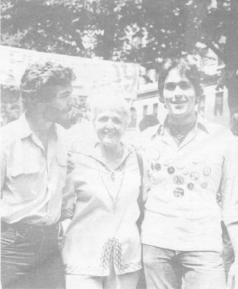 An older woman at Gay Pride Day 1975 standing with two young men