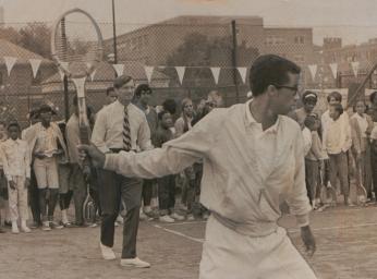 Arthur Ashe teaching children how to play tennis.