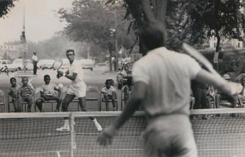 Arthur Ashe and Charlie Pasarell playing tennis in the street.