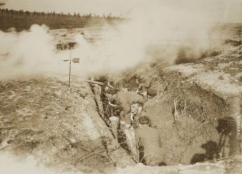 soldiers in trenches train for gas exposure with masks on and smoke billowing over their heads as they move (source: National Archives)