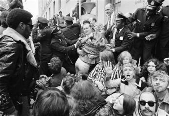 An employee of the Justice Department is helped over demonstrators blocking the entrance to the building in Washington, May 1, 1971