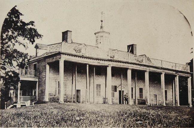 Photograph of Mount Vernon in poor condition from the Potomac side; timbers and ship masts hold up a sagging roof.