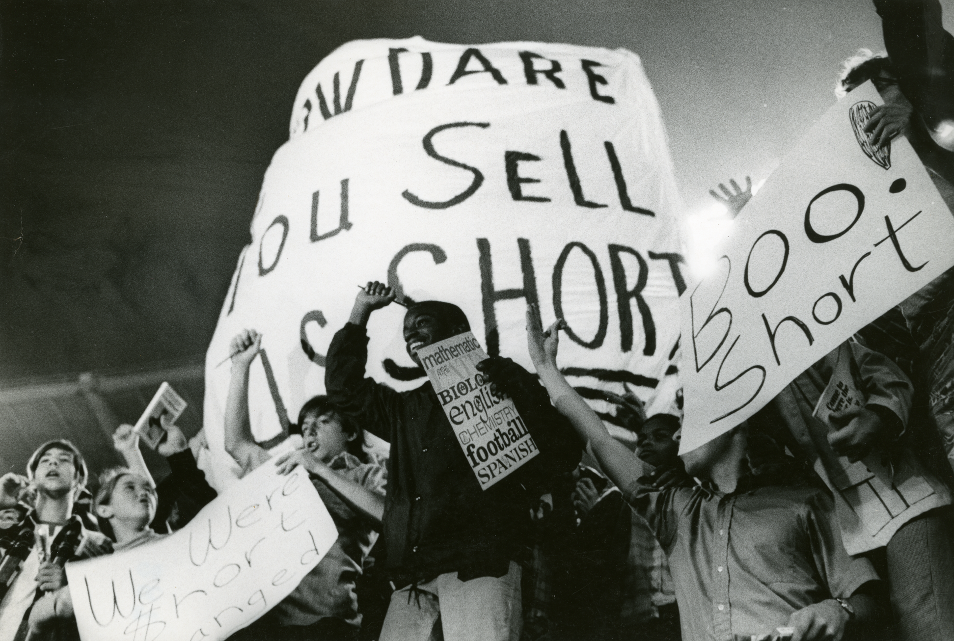 Fans cheer on the Senators while holding various anti-Bob Short signs. 
